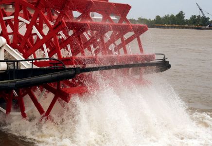 Close-up of red paddle boat wheel splashing in the water