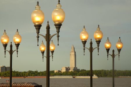 Lighted lampposts; river, barges, city beyond
