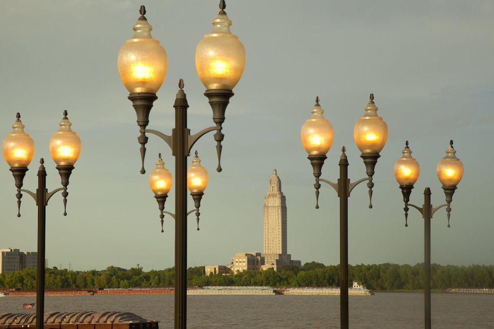 Lighted lampposts; river, barges, city beyond