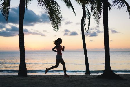Woman running at dusk on tropical beach