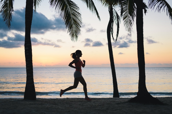 Woman running at dusk on tropical beach