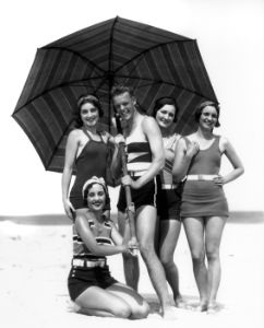 Four Women And One Man Under Beach Umbrella In Bathing Suits;  F